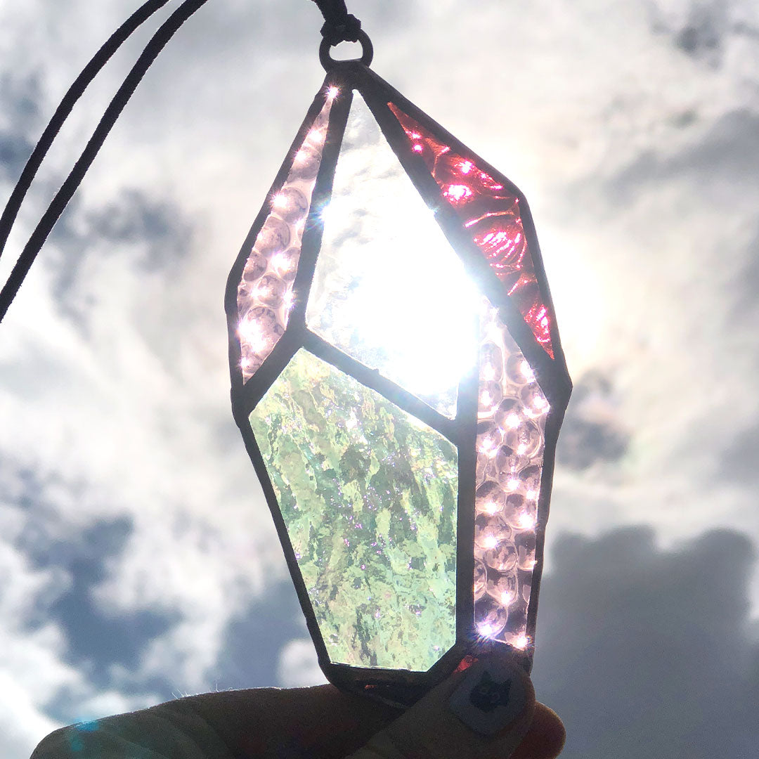 Purple and clear crystal sun-catcher showing sunlight shining through it